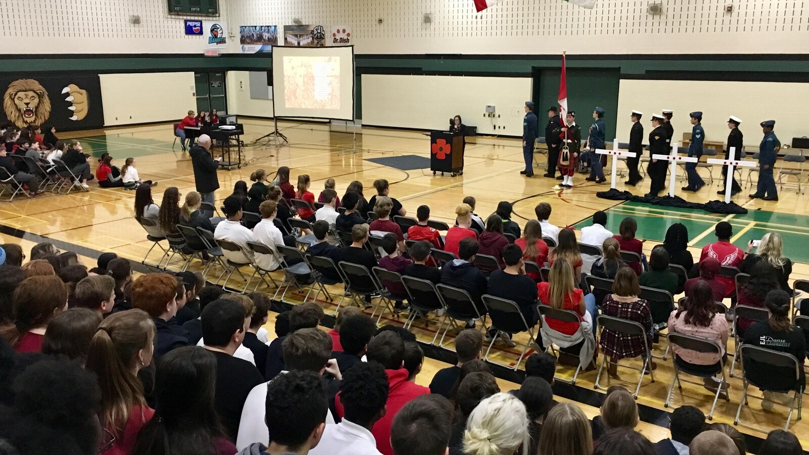 Une foule d'élèves de dos observent la cérémonie.