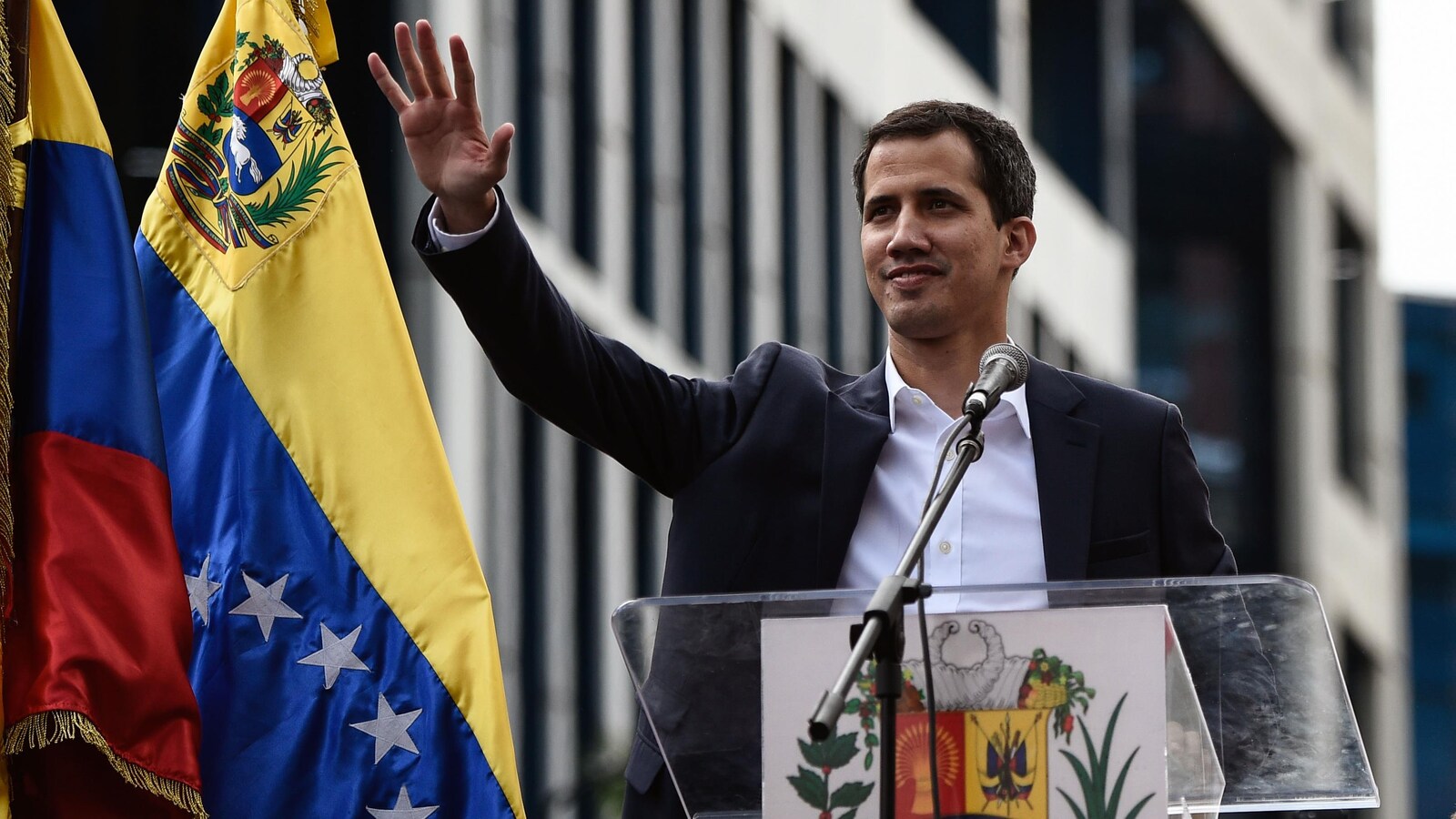 Juan Guaido est à l'extérieur et parle à la foule massée devant lui sur une estrade.