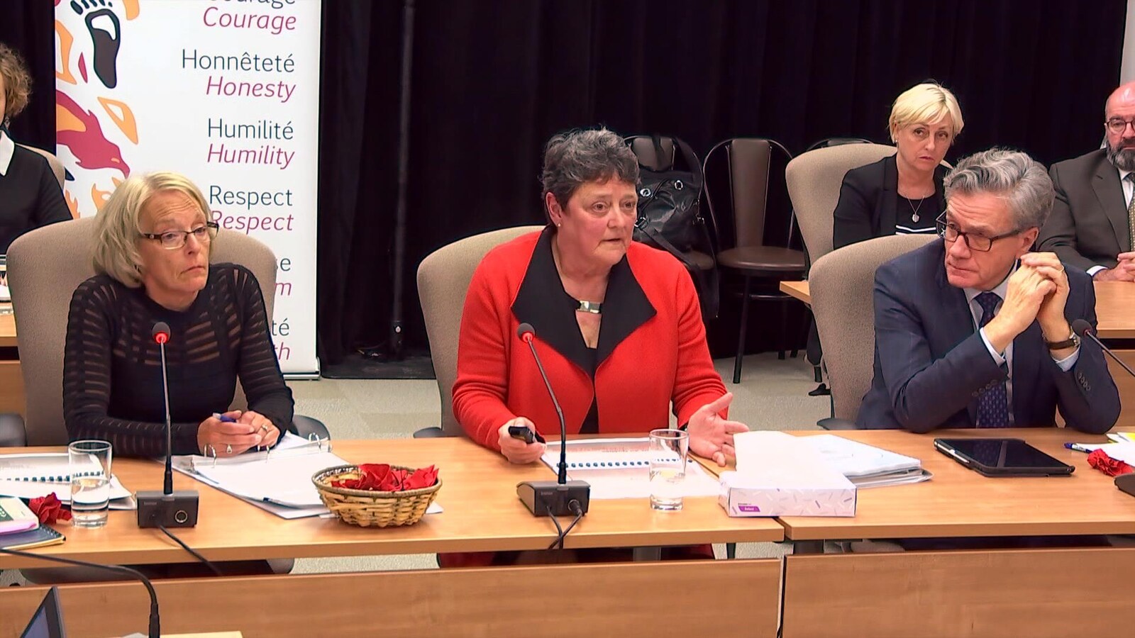 Deux femmes et un homme témoignent lors d'une commission d'enquête.