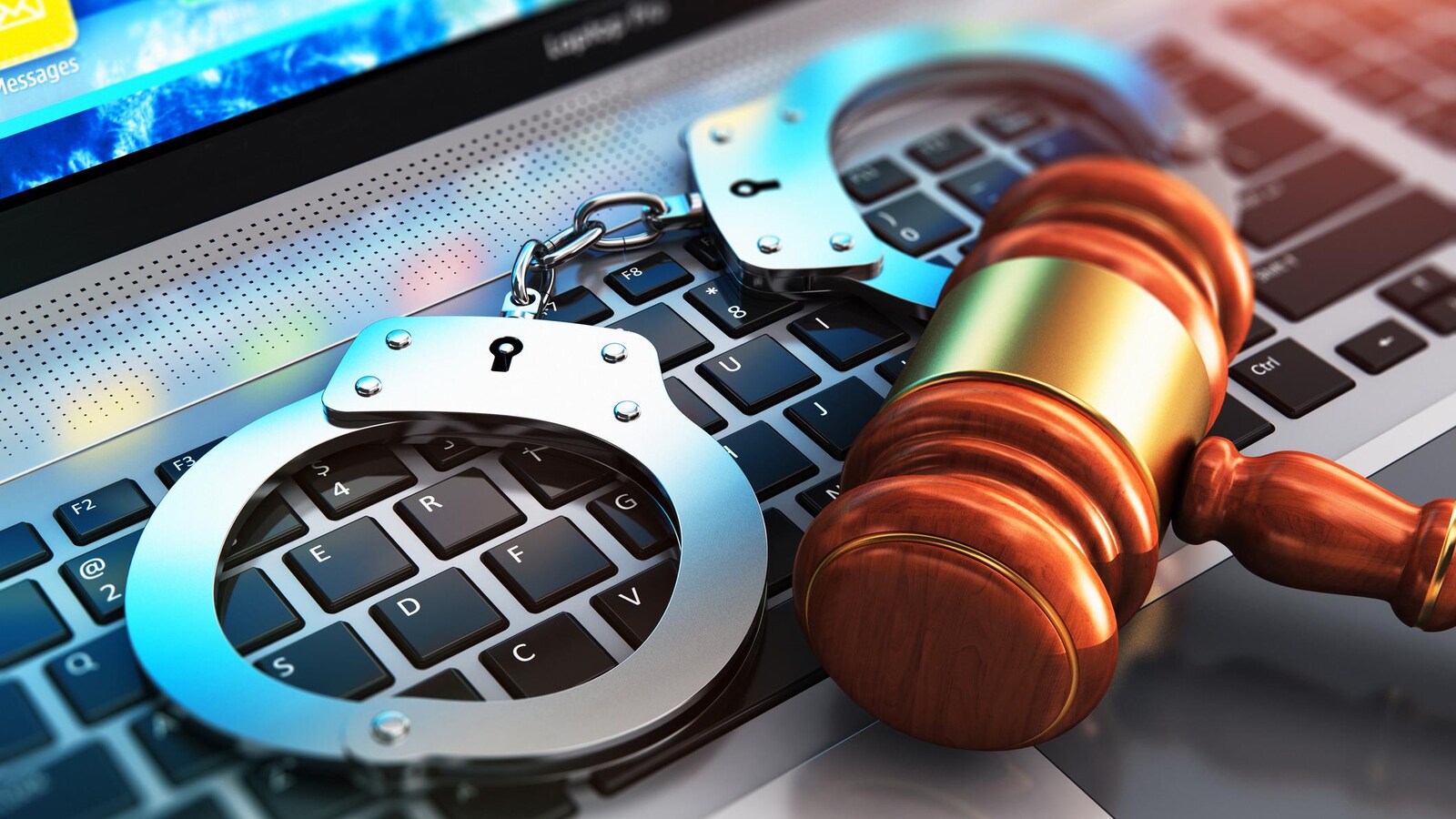 Sur un clavier d'ordinateur repose des menottes ainsi qu'un maillet représentant la justice.