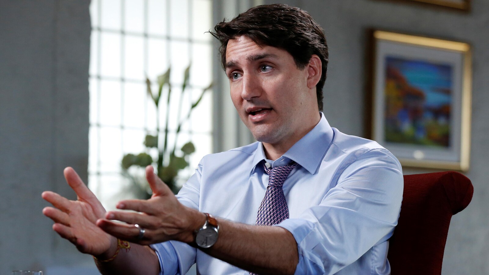 Justin Trudeau, assis sur chaise, regarde un interlocuteur qu'on ne voit pas.