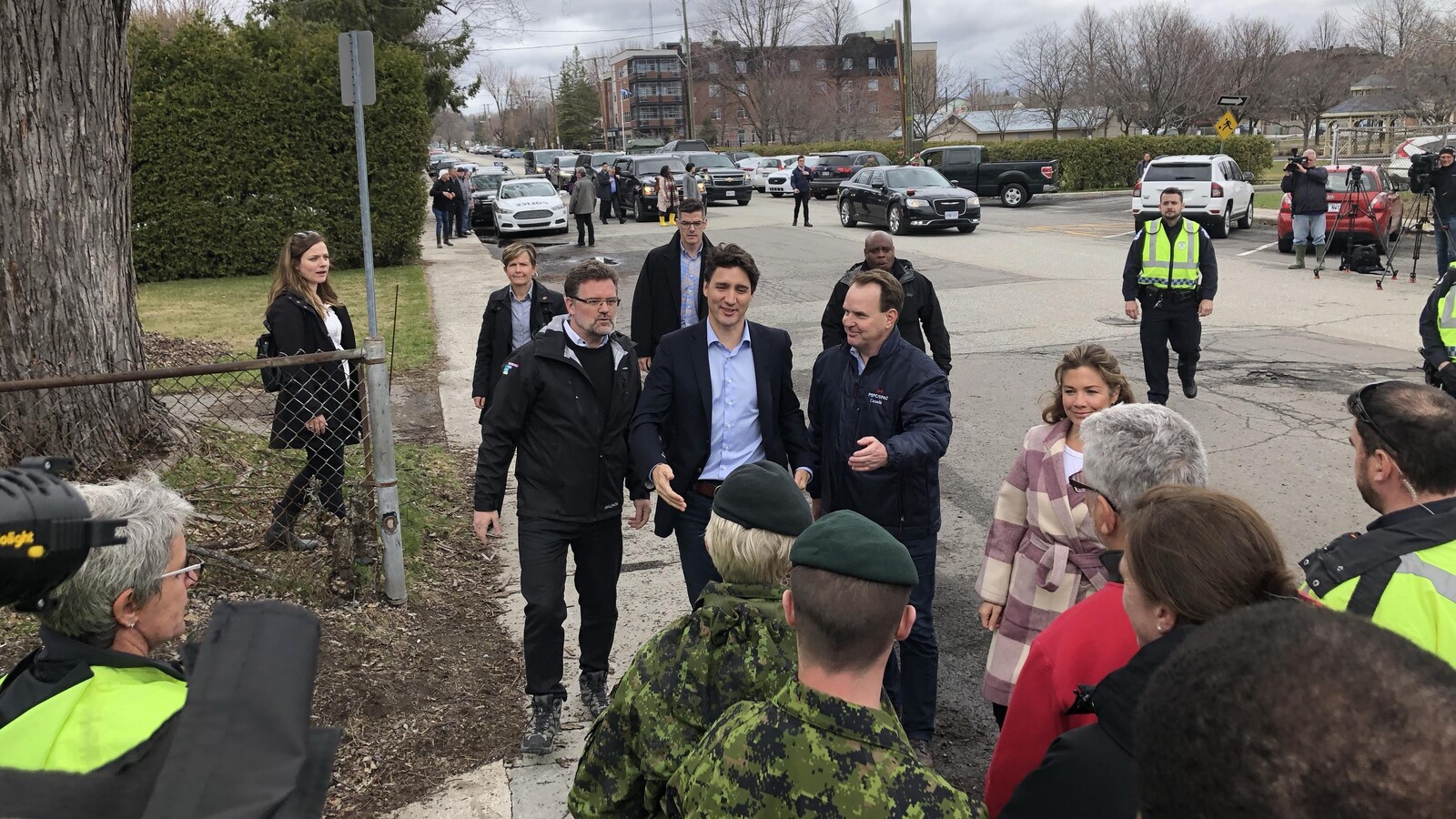 Justin Trudeau marche sur le trottoir, entouré de collègues et de membres des forces de sécurité.