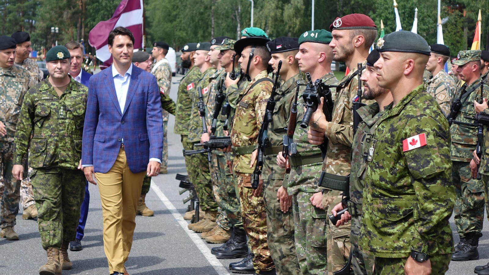 Justin Trudeau inspecte les troupes de l'OTAN dont les soldats sont en rang.
