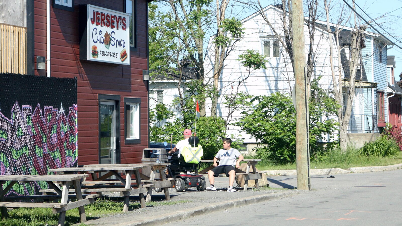 Des clients prennent une pause devant un casse-croûte de la communauté mohawk de Kahnawake, située près de Montréal.