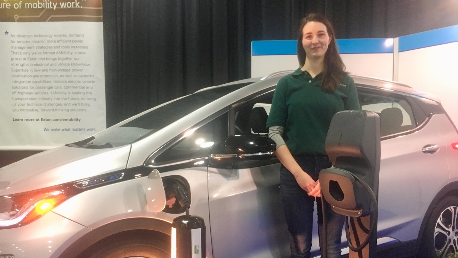 Jeune femme devant une voiture électrique