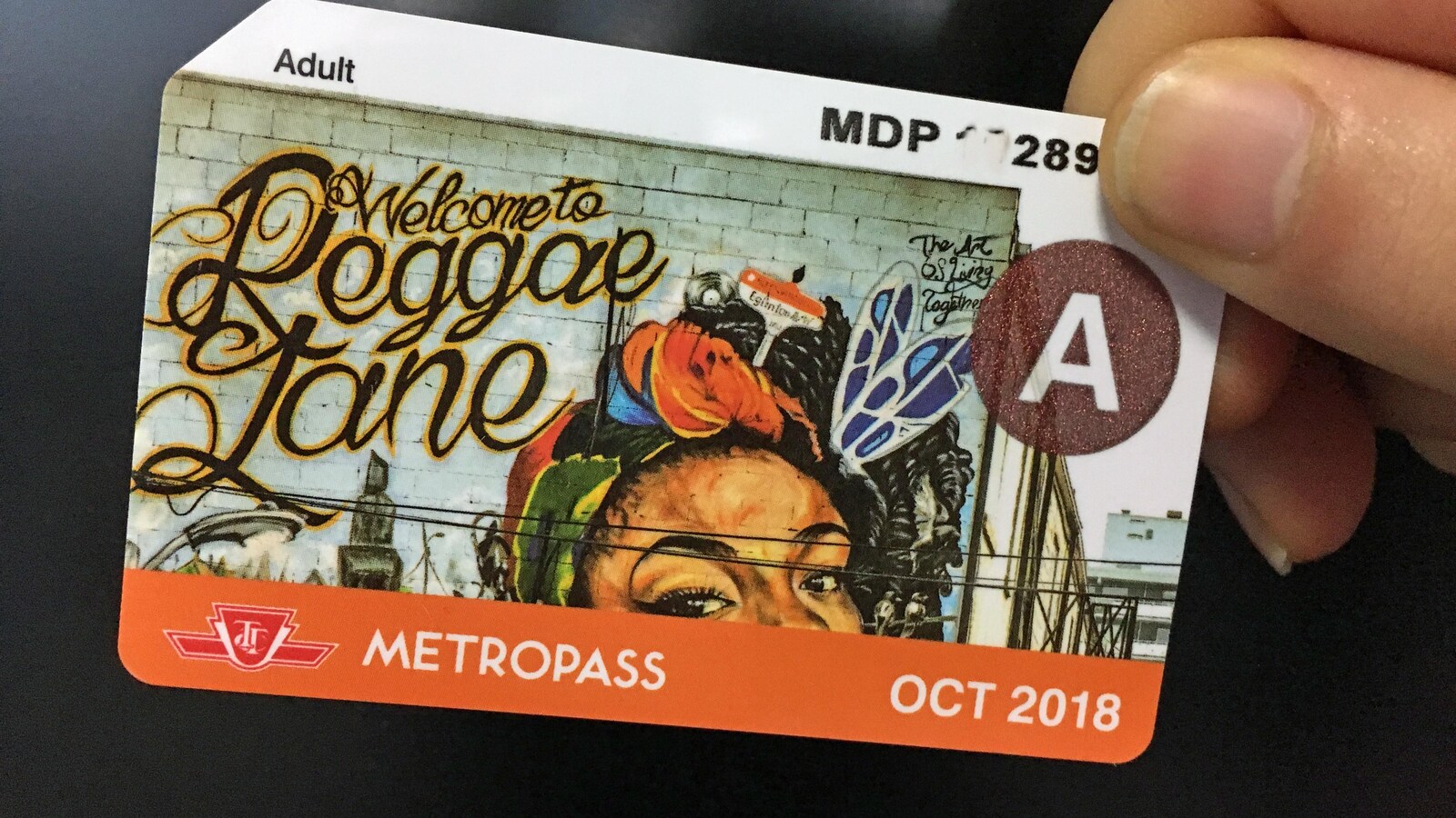 Photo d'une main qui tient une carte de plastique pour le transport en commun.