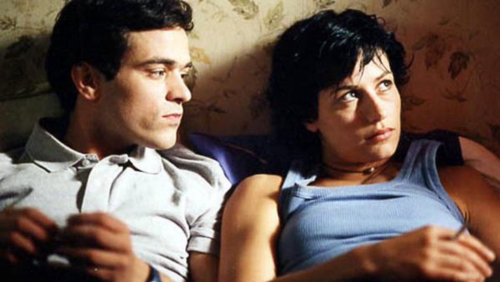 Un homme et une femme sont allongés côte à côte dans un lit.