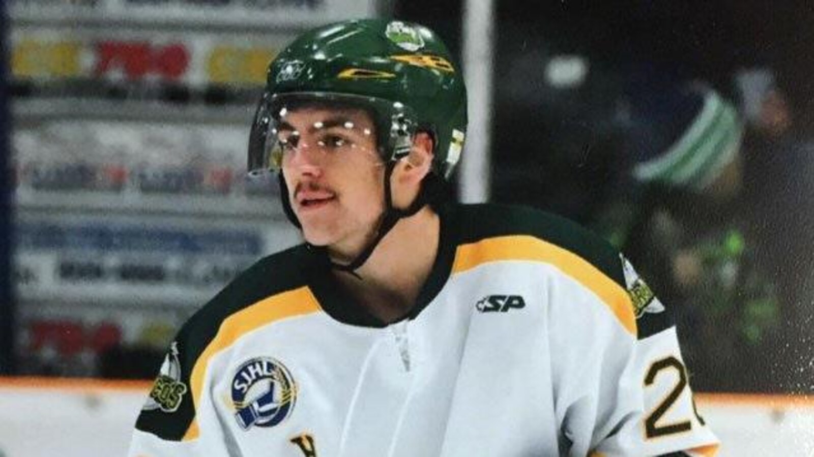 Layne Matechuk sous les couleurs des Broncos de Humboldt en blanc, vert et jaune, lors d'un match de hockey.
