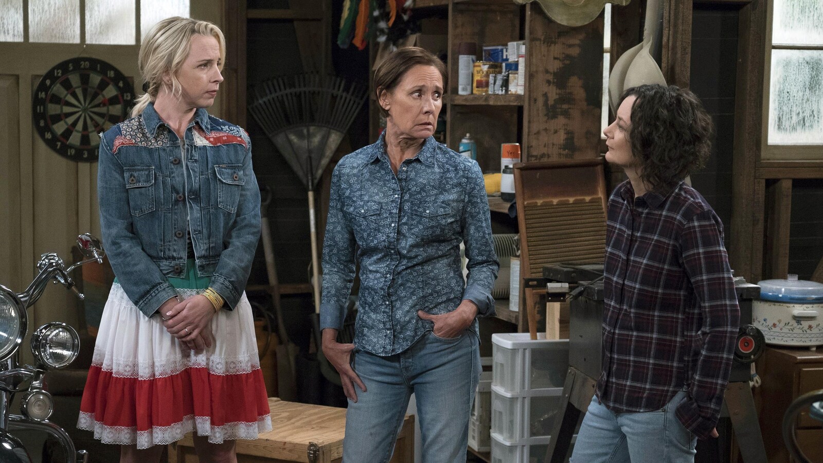 Lecy Goranson et Laurie Metcalf regardent Sara Gilbert alors qu'elles se trouvent dans une pièce qui semble être une débarras.