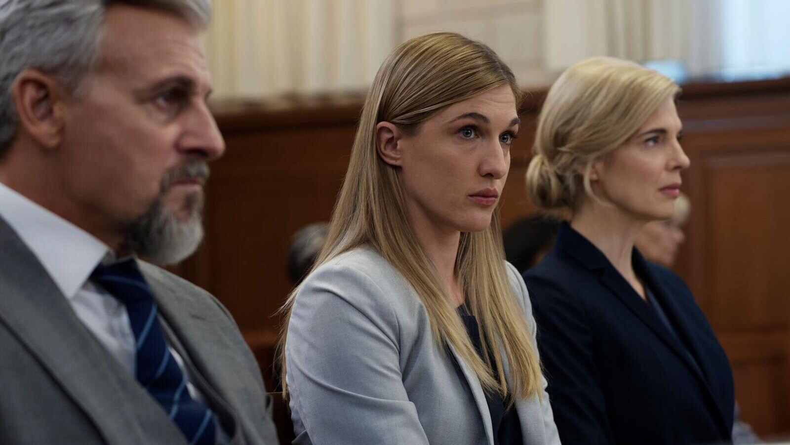 Les trois personnes sont assises côte à côte.