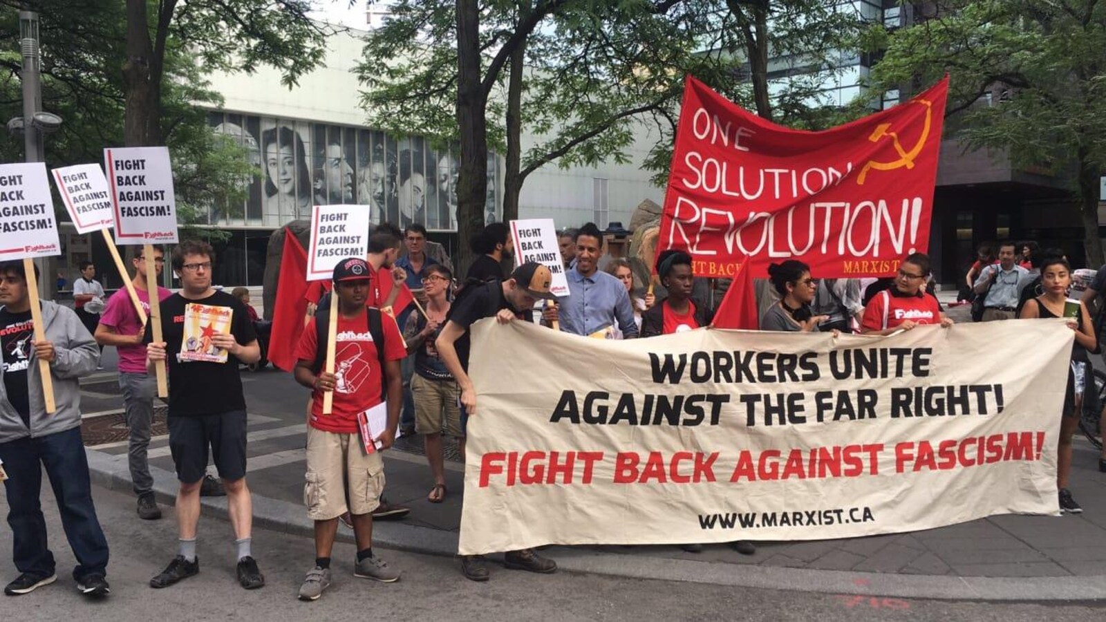 Un groupe de manifestants antifascistes brandissent des banderoles.