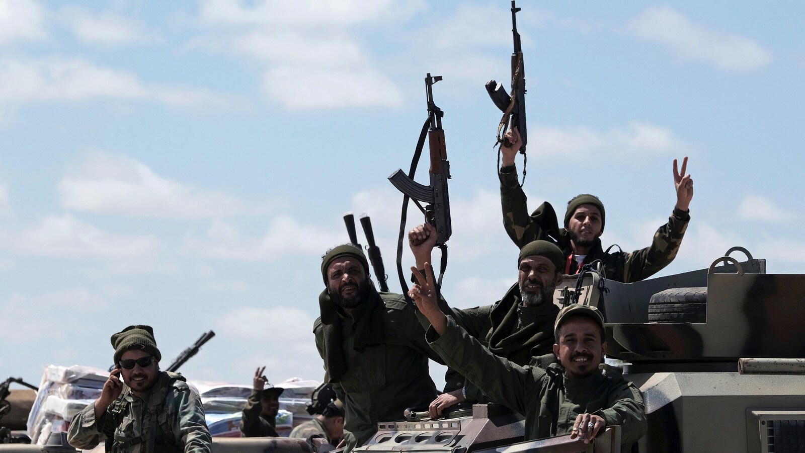 Des membres de l'Armée nationale libyenne font le signe de la victoire avec leurs doigts.