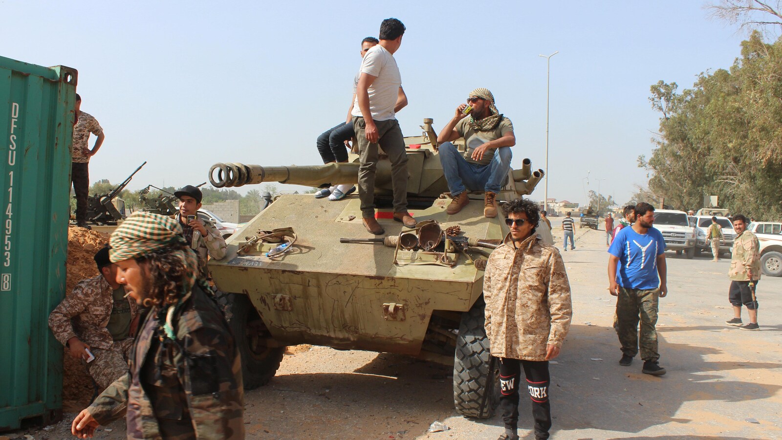 Des membres du gouvernement libyen reconnu par la communauté internationale entourent un blindé stationné non loin de la capitale, Tripoli.
