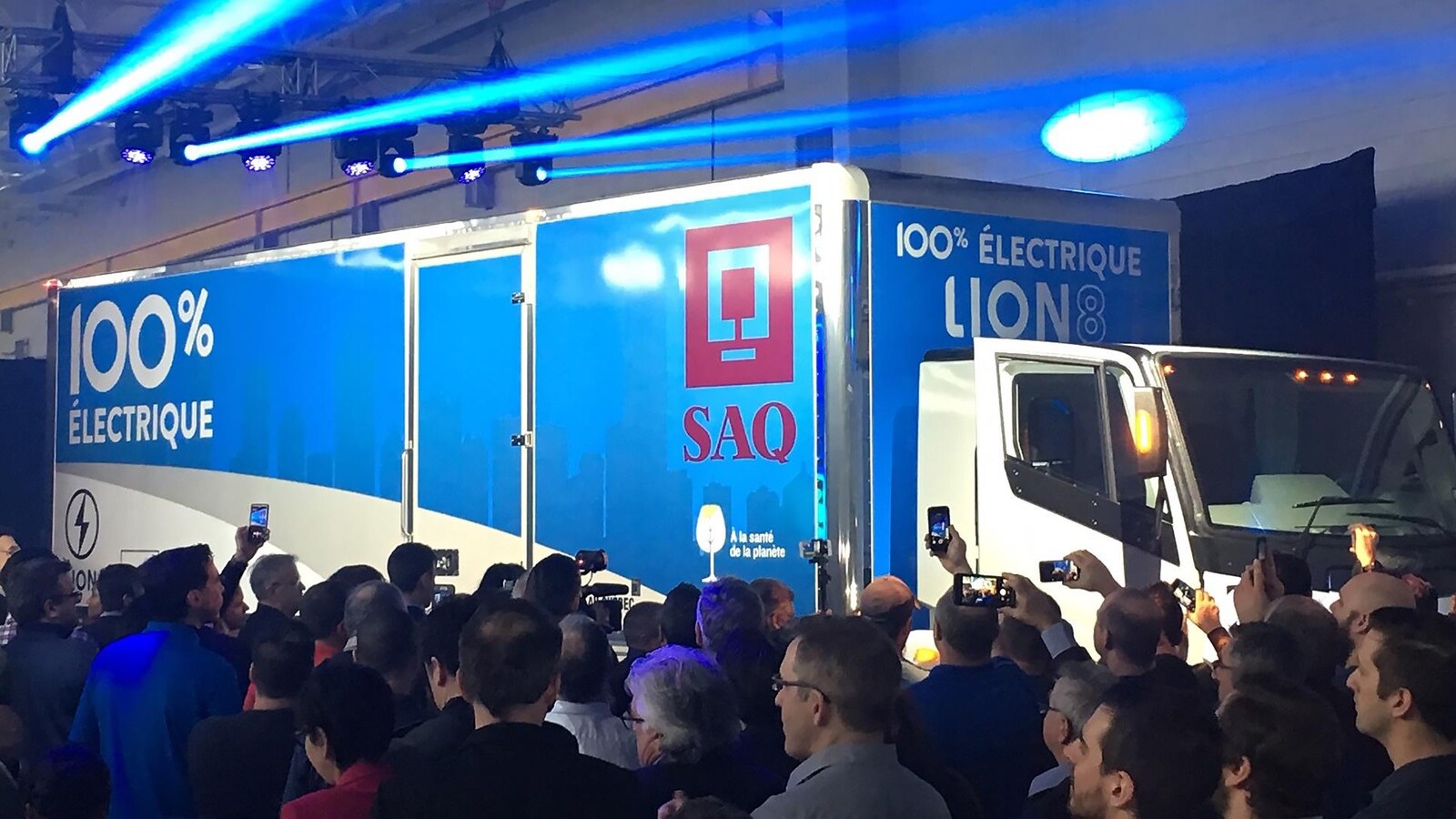 Les travailleurs de l'usine filment le dévoilement du camion avec leur téléphone.