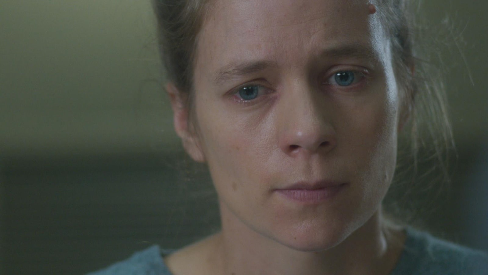 L'actrice Livia Sassoli regarde dans le vide, les larmes aux yeux.