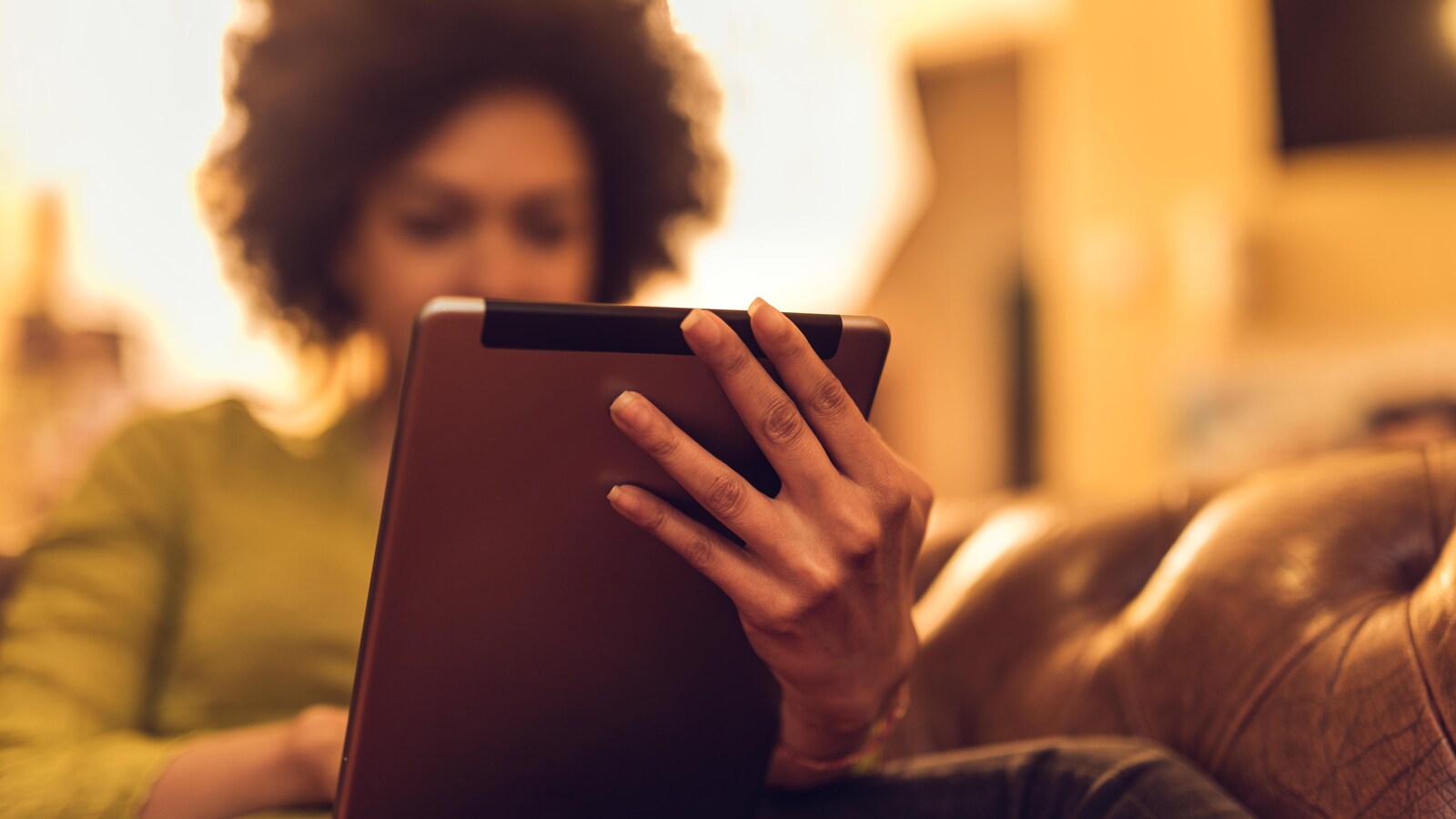 Une femme lit un ouvrage sur son iPad.