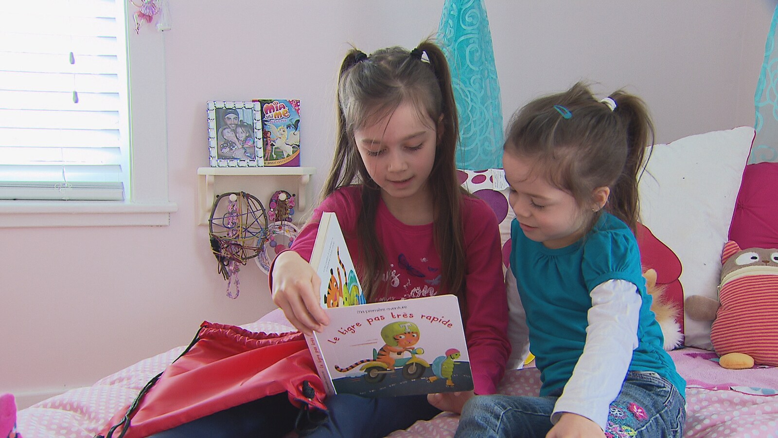 Béatrice Michaud, 7 ans, fait la lecture à sa soeur Mathilde, 3 ans.