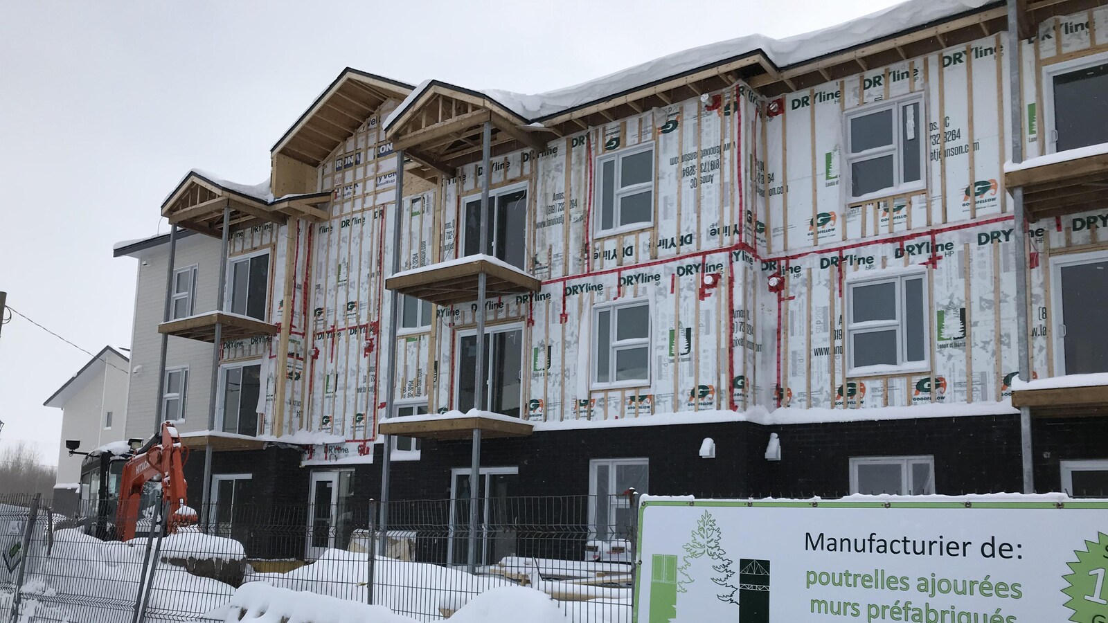 Un immeuble à logements en construction, l'hiver.