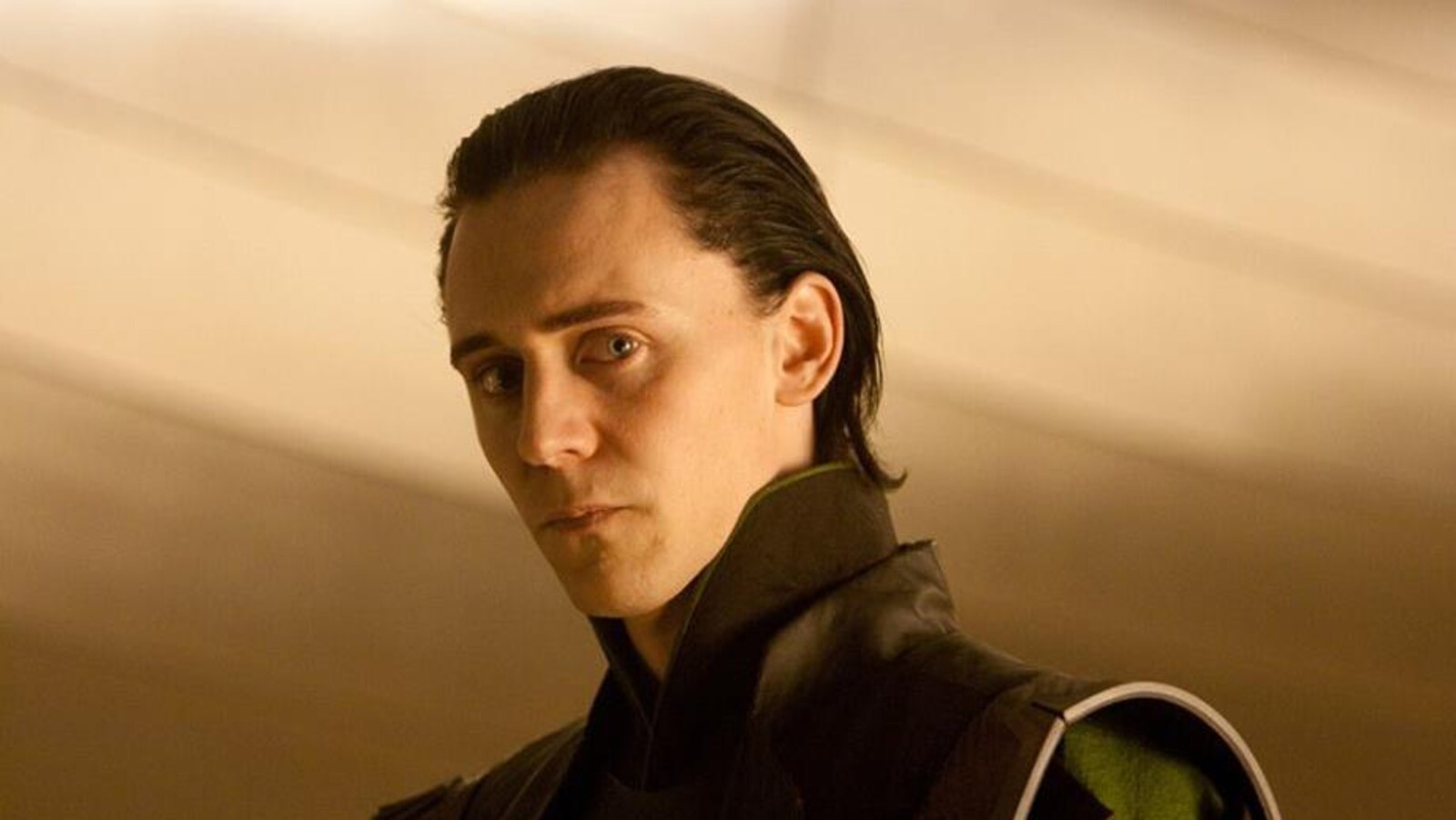 Quasiment de profil, Tom Hiddleston regarde l'objectif.