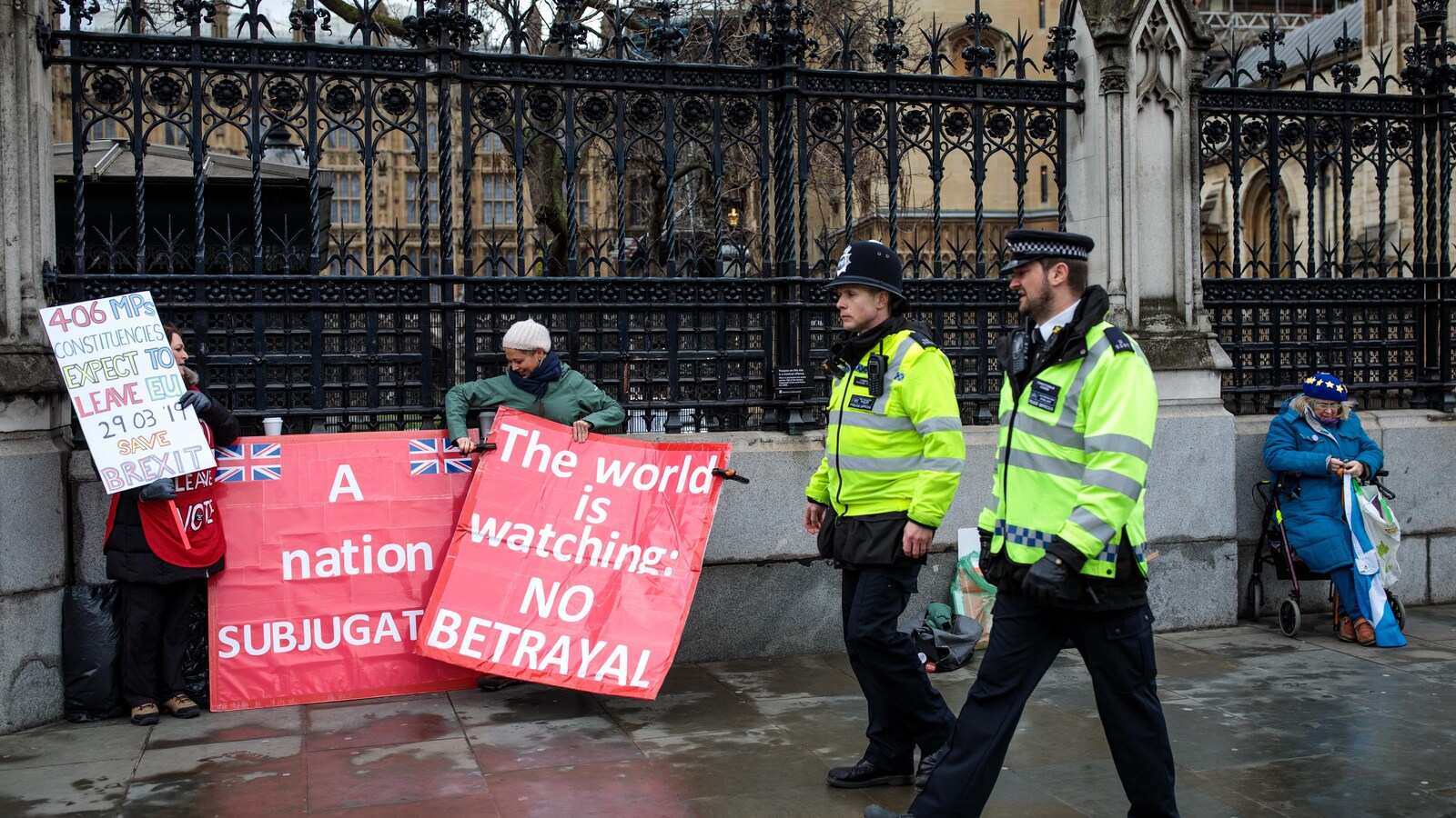 Des policiers passent devant des manifestantes devant le parlement britannique à Londres