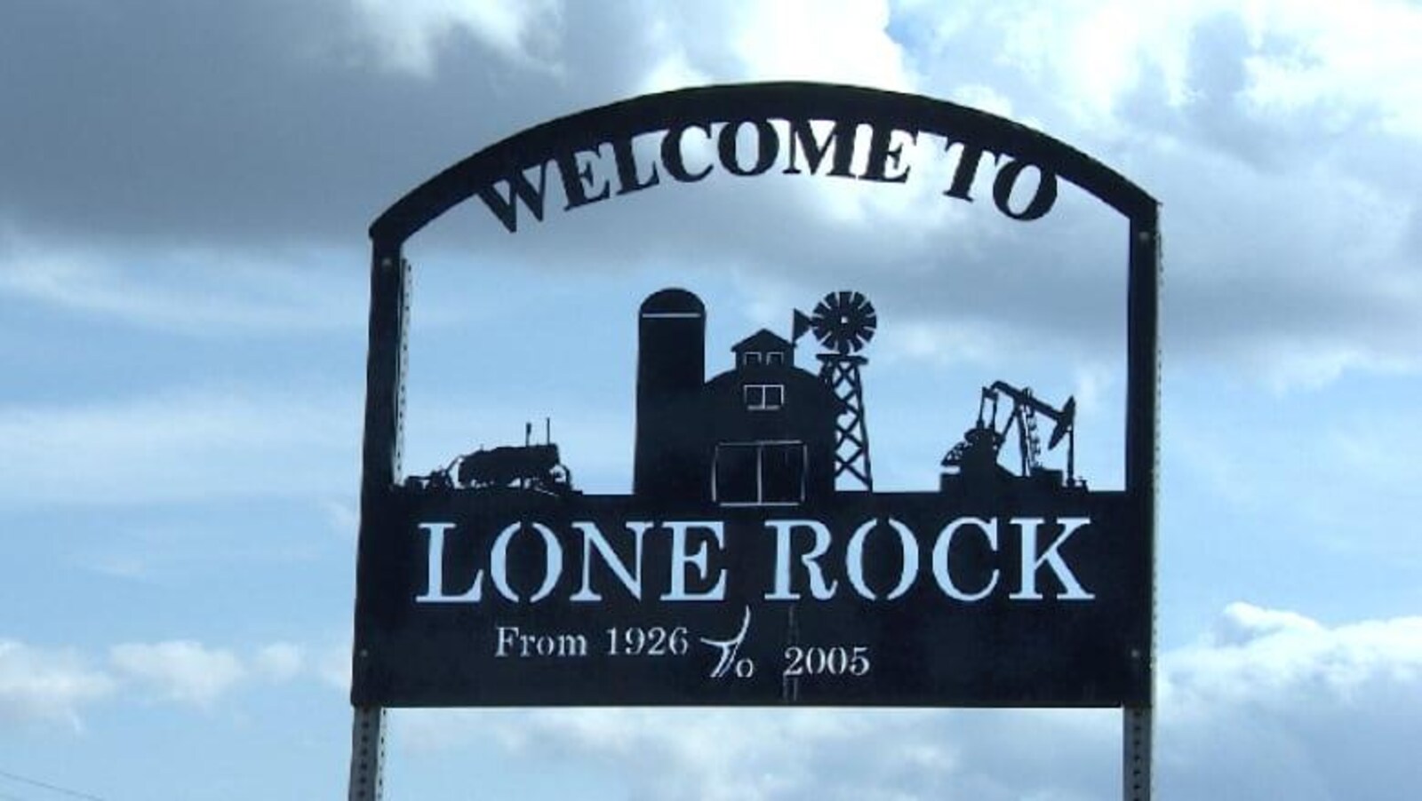 On lit en anglais sur un écriteau en métal : Bienvenue à Lone Rock, de 1926 à 2005.