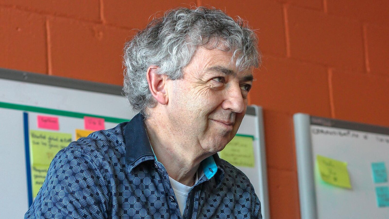 un homme qui regarde à côté de la caméra