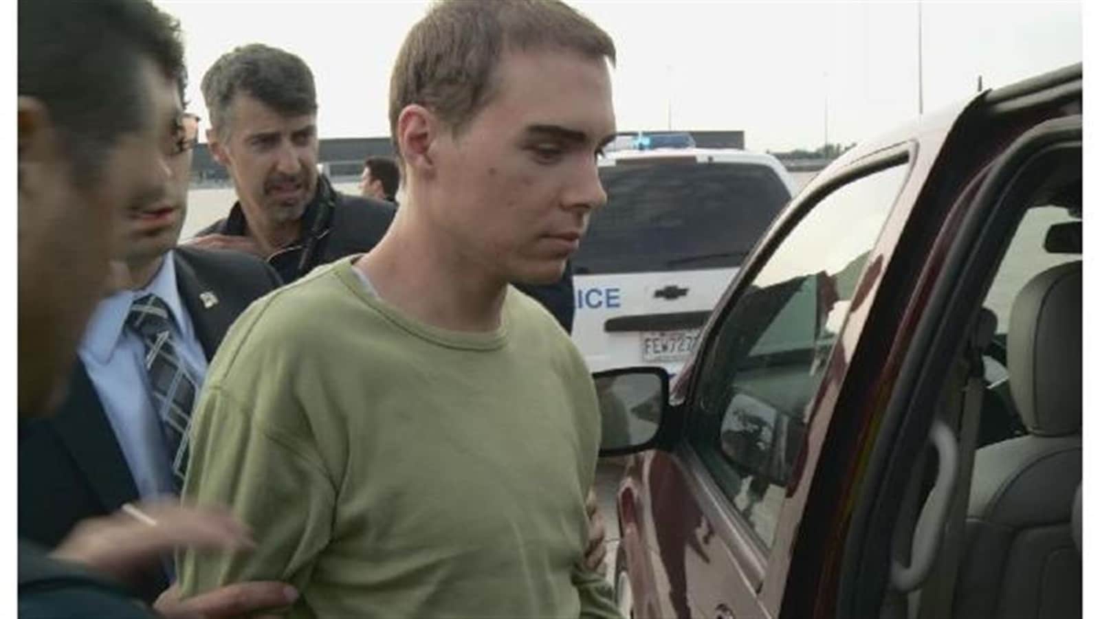 Luka Rocco Magnotta lors d'un transfert, avec des policiers.