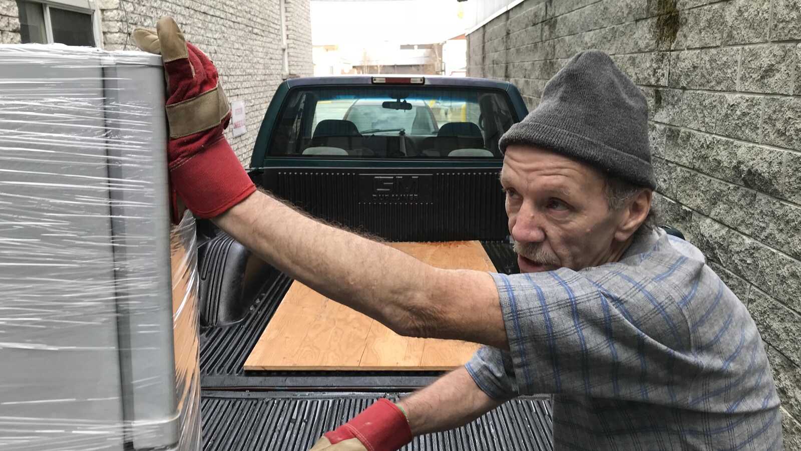 Magela Gamelin est en train de pousser un réfrigérateur pour le mettre dans la boîte d'un camion.