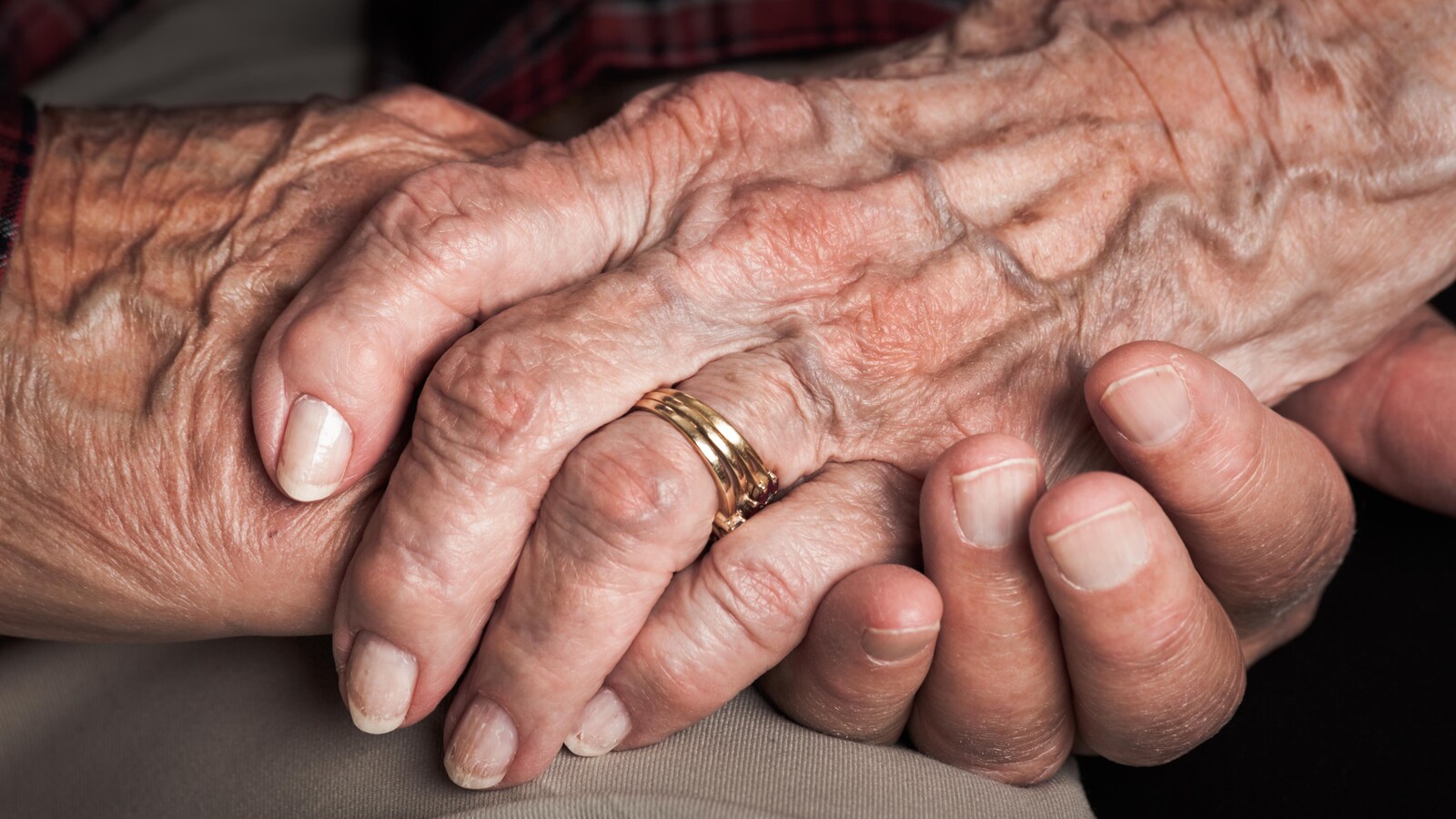 Les mains enlacées d'un couple d'aînés