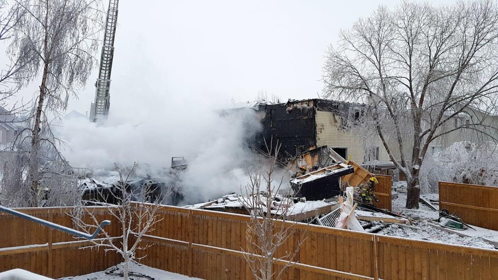 De la fumée émerge des décombres de la maison détruite par une explosion.