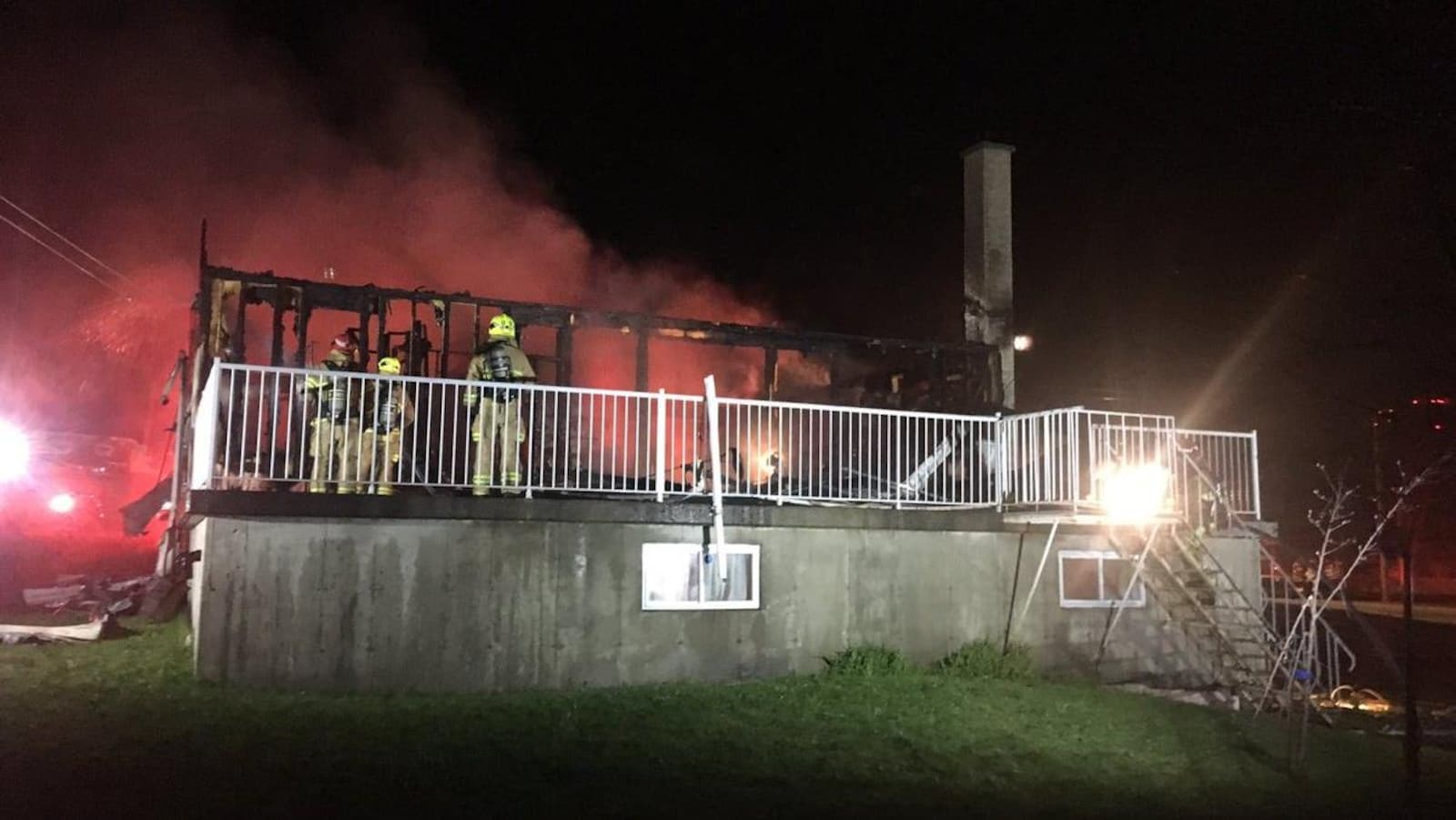 Des pompiers inspectent les décombres d’une résidence ravagée par les flammes.