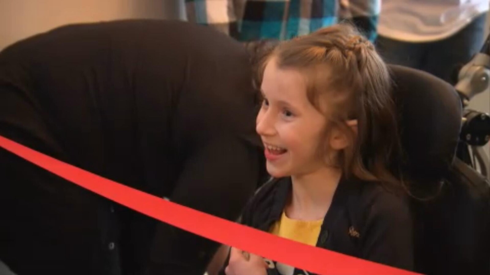 Océane McKenzie sourit devant un ruban rouge.