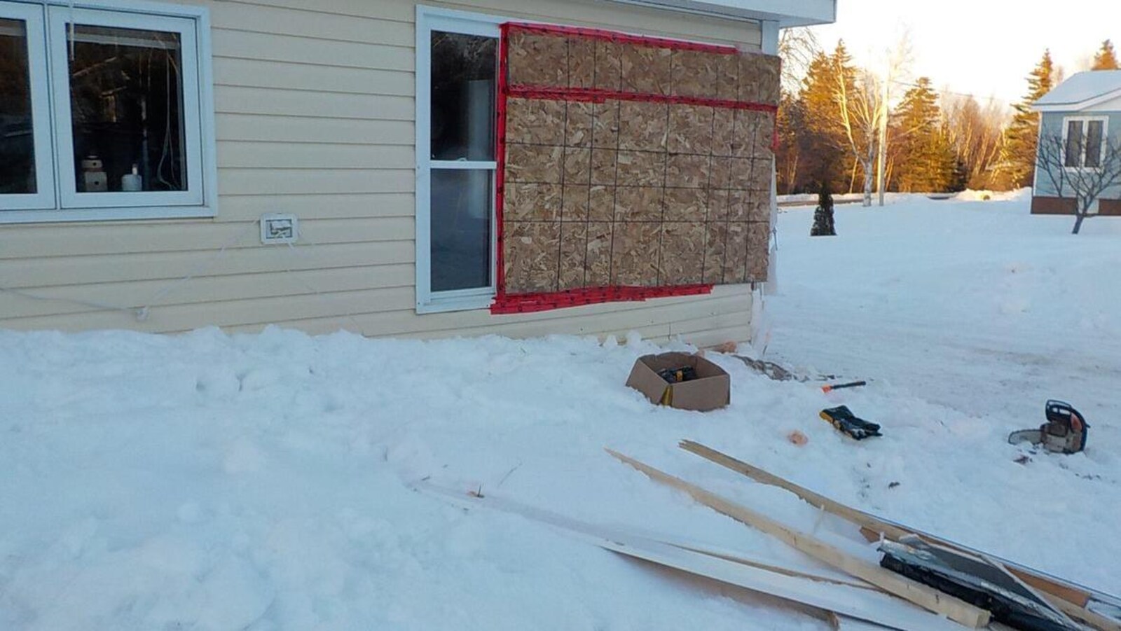 Une planche de contreplaqué recouvre les fenêtres fracassées de la maison des Porter.