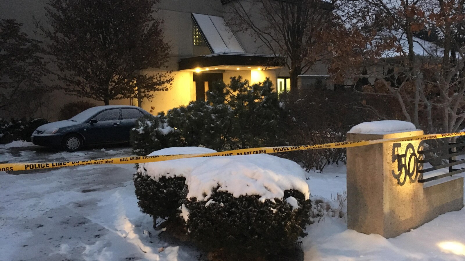 Une maison ceinturée par un cordon jaune indiquant la tenue d'une enquête policière.