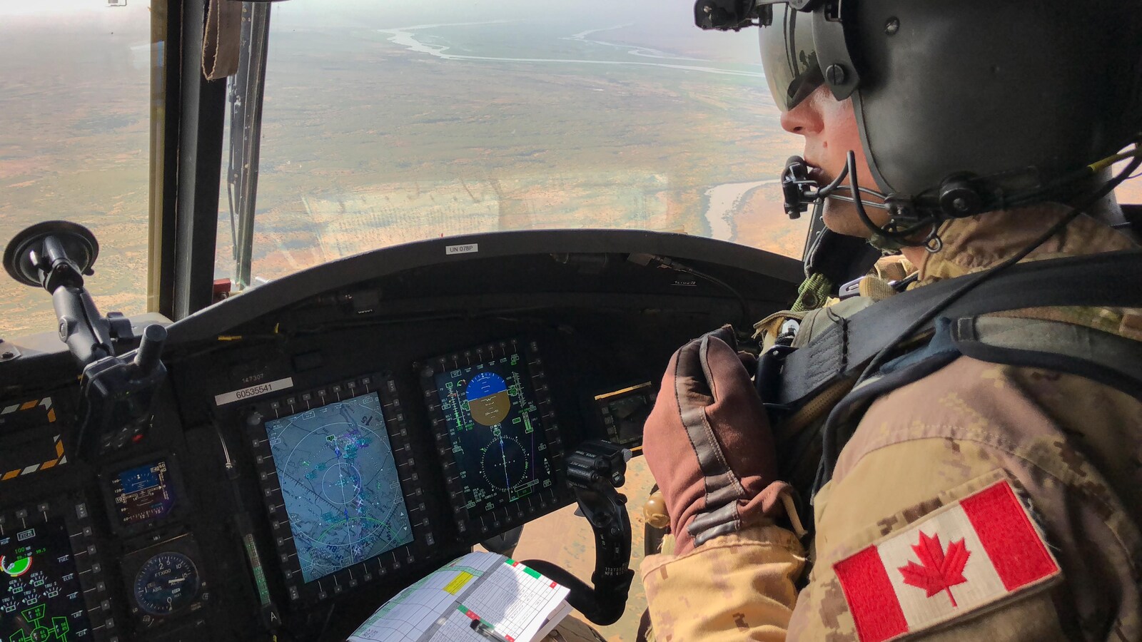 Dans le cockpit, le Major Dominique Simard aux commandes d'un Chinook, en plein vol au dessus du Mali.
