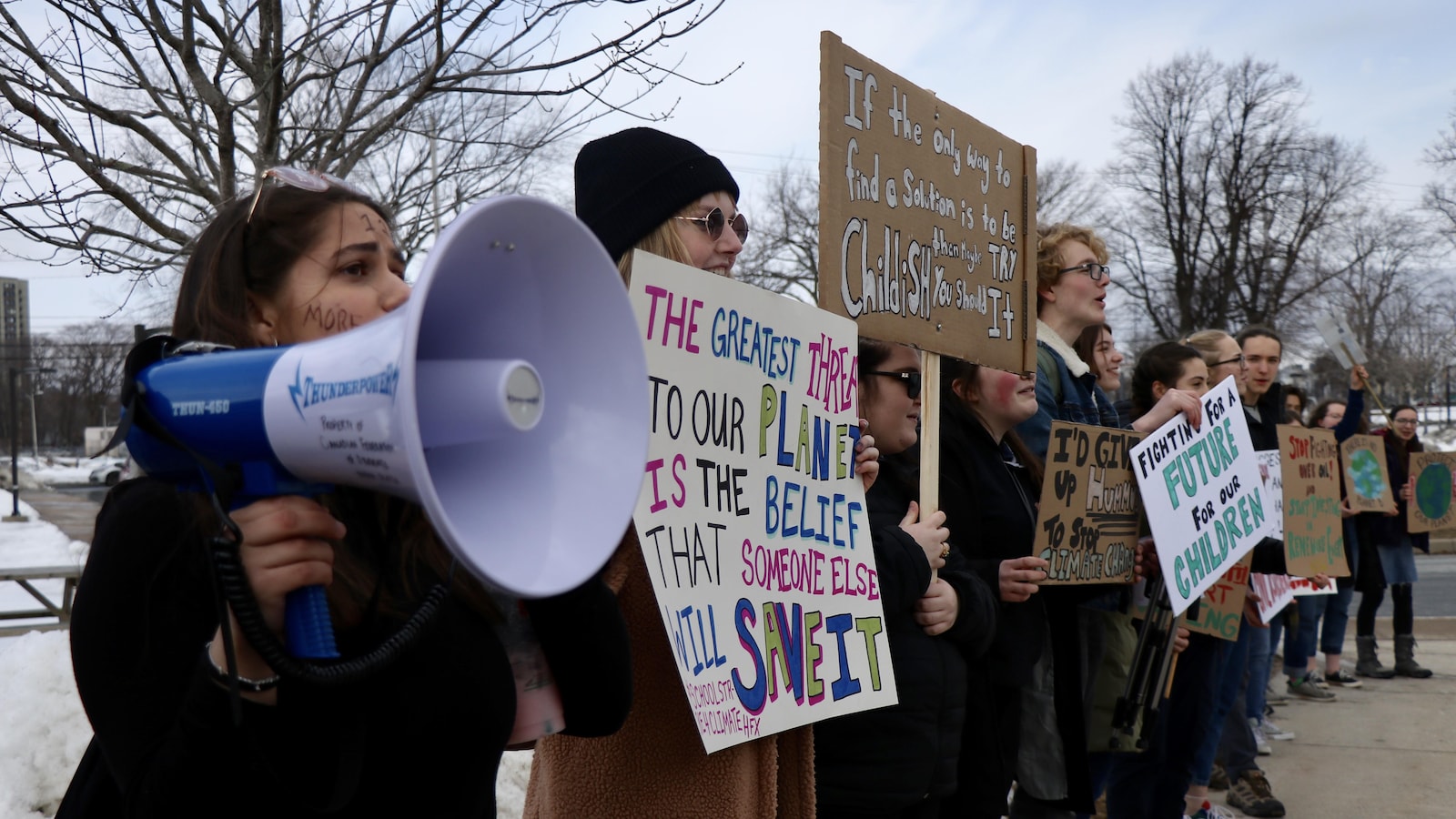 Une dizaine d'élèves d'Halifax manifestent avec pancartes et un porte-voix.
