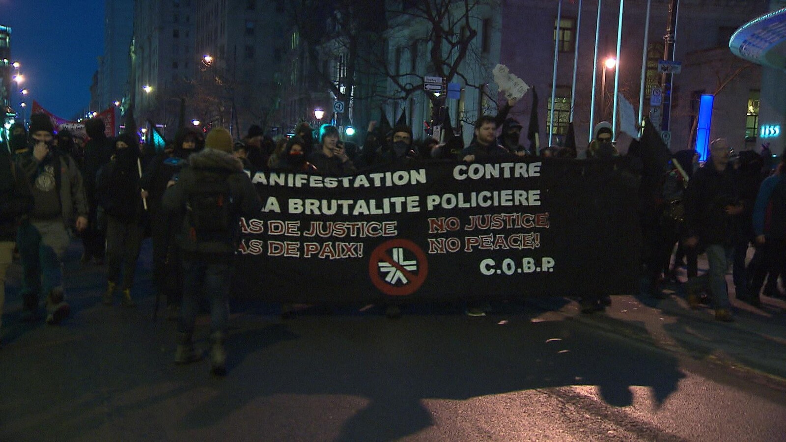 Des manifestants portent une banderole sur laquelle on peut lire «manifestation contre la brutalité policière. Pas de justice, pas de paix».