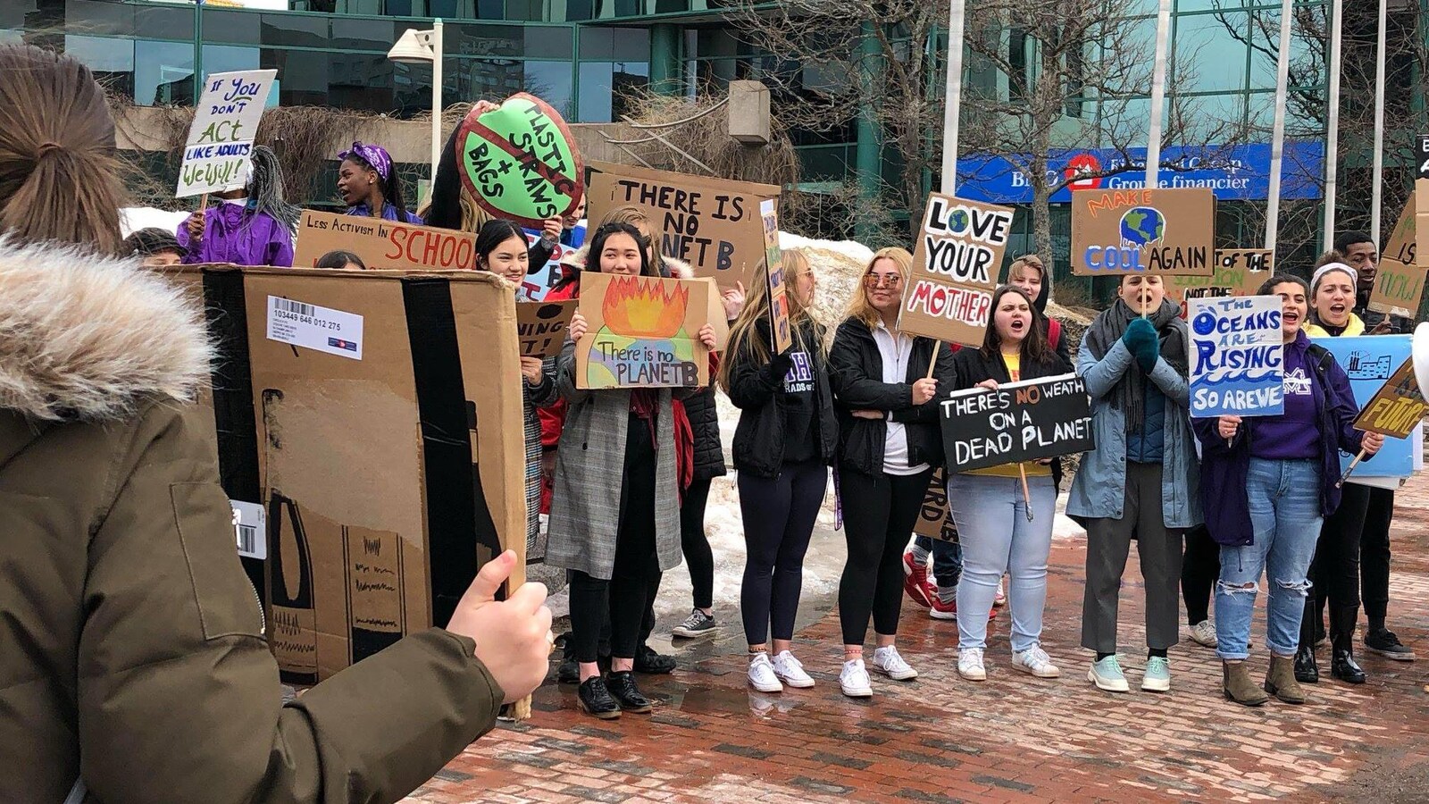 Des jeunes tiennent des pancartes.