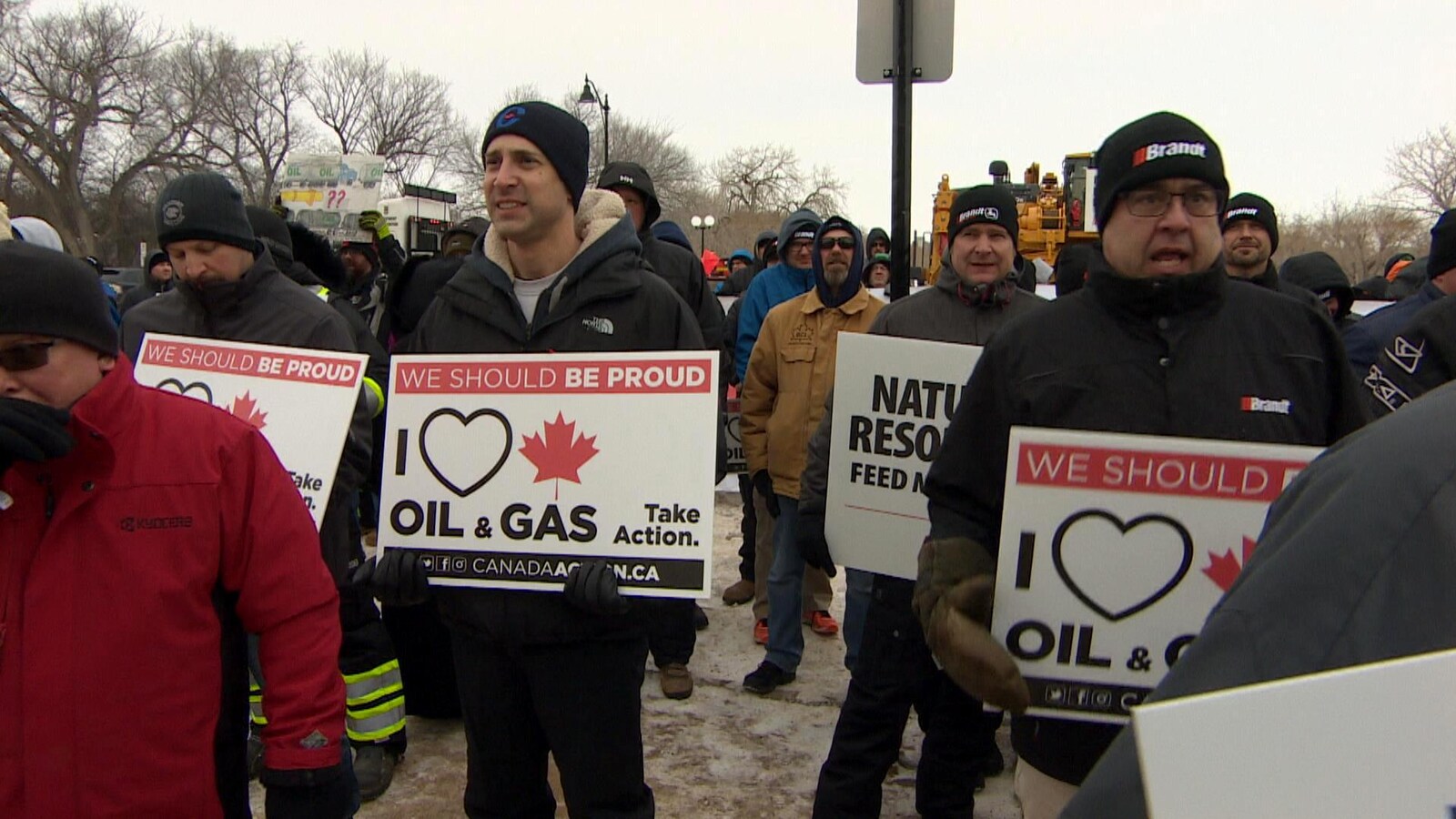 des manifestants porte des pancartes sur lesquelles on peut lire en anglais: "J'aime le pétrole et le gaz, agissons"