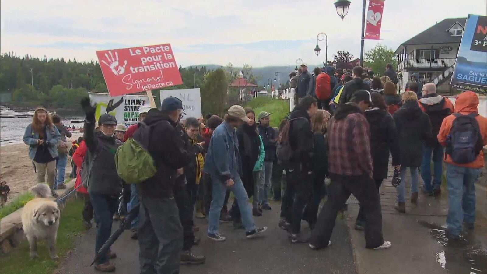 Des manifestants marchent à proximité d'un cours d'eau.