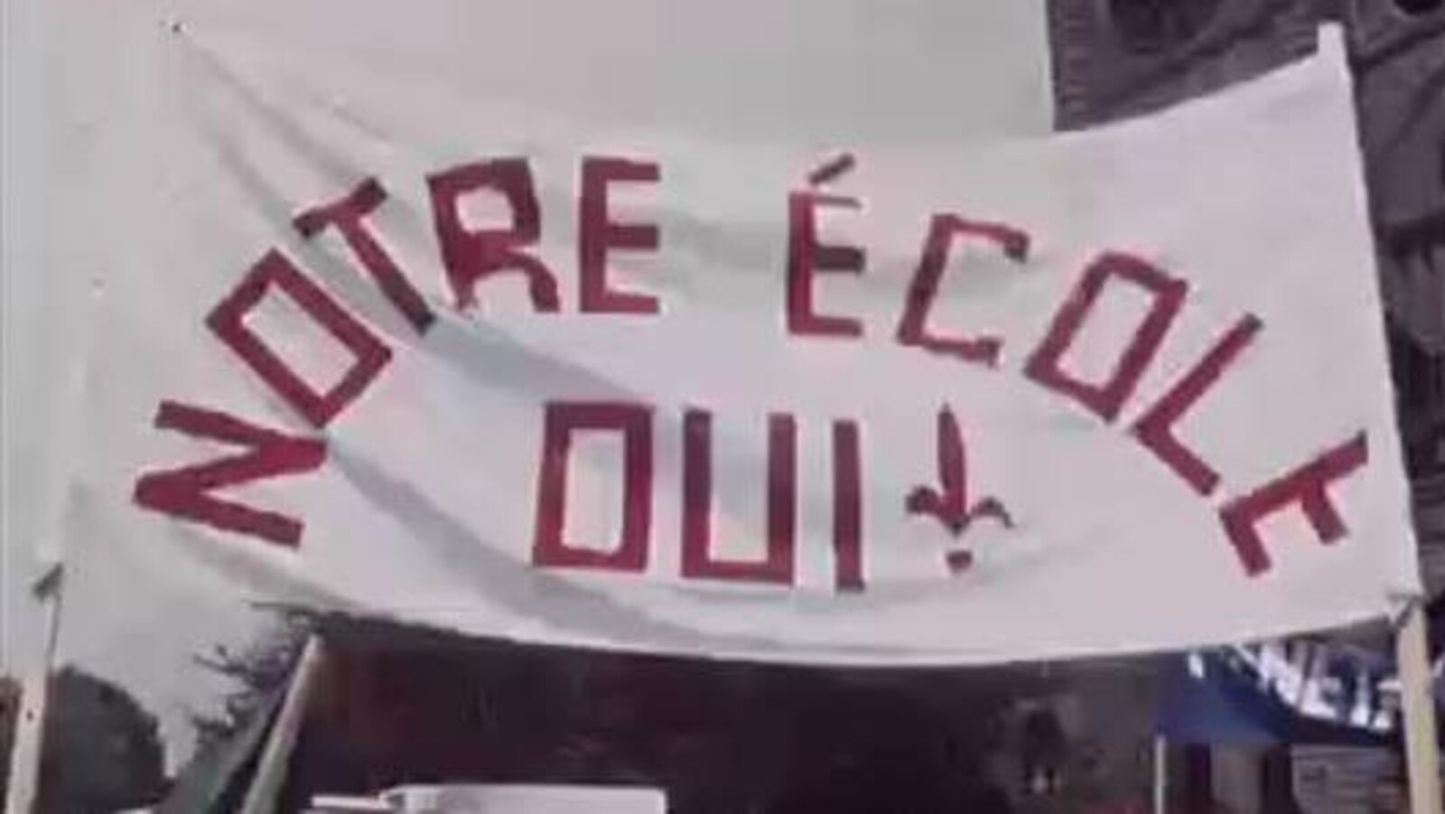 Grande bannière avec l'inscription «Notre école OUI» dans une manifestation