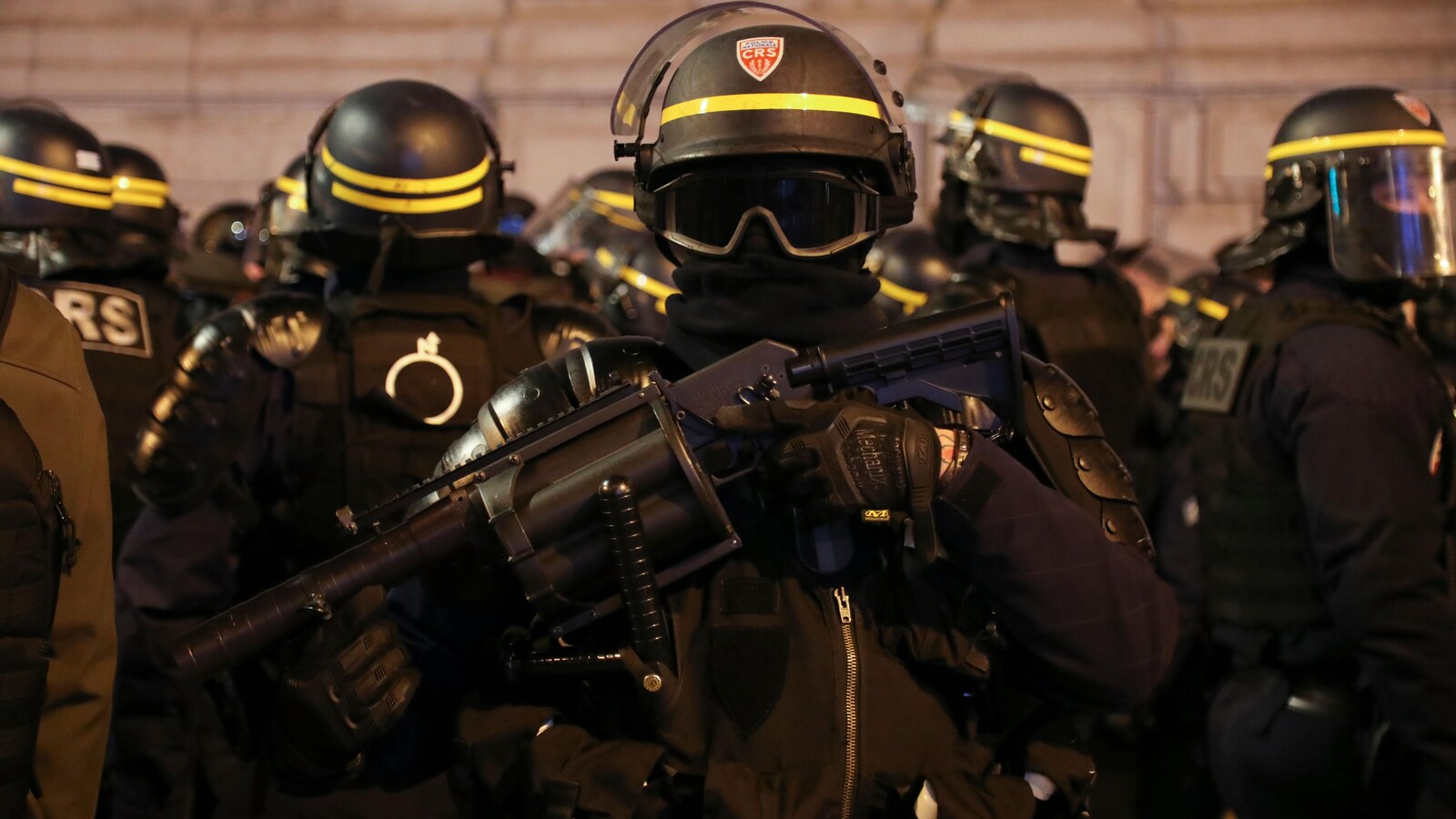 Un membre des forces anti-émeutes portant un lanceur de grenades de gaz lacrymogène à Paris lors d'une manifestation des gilets jaunes.