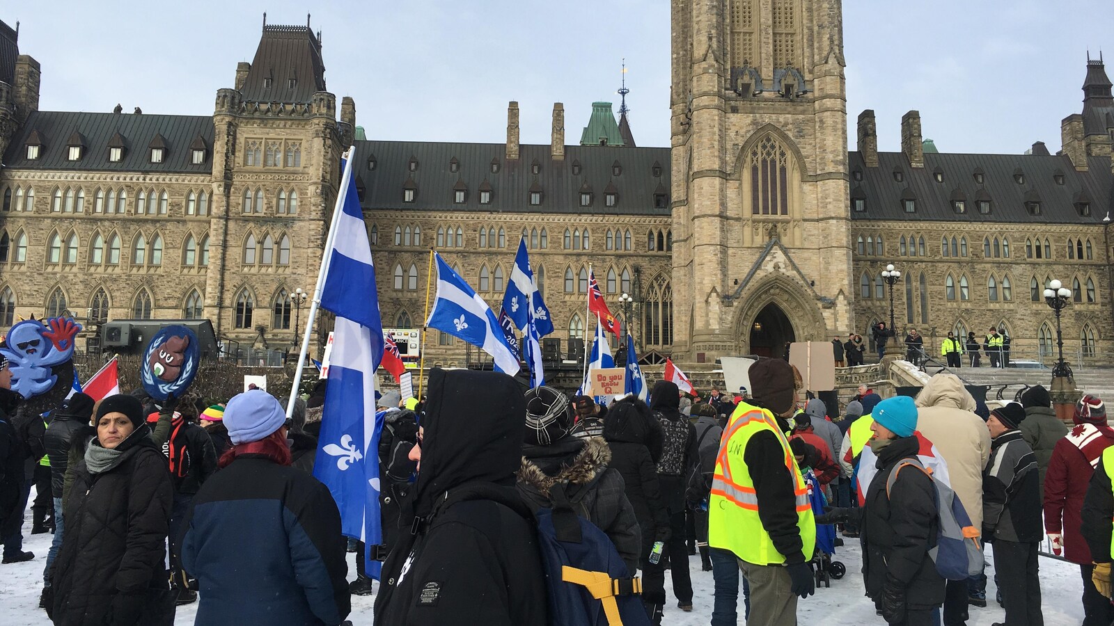 Des manifestants avec des drapeaux québécois devant le Parlement