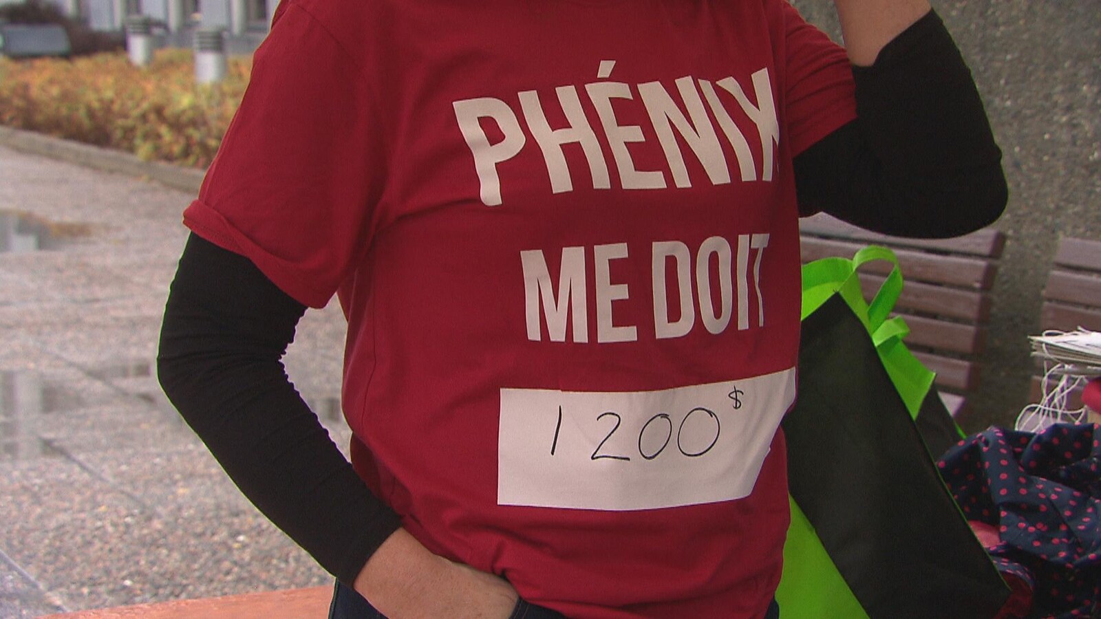 Un manifestant arborant un chandail sur lequel est inscrit que le système de paye Phénix lui doit 1200$.