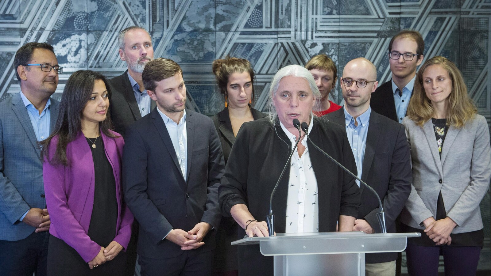Manon Massé parle en conférence de presse, tous les députés élus de QS se tiennent derrière elle.