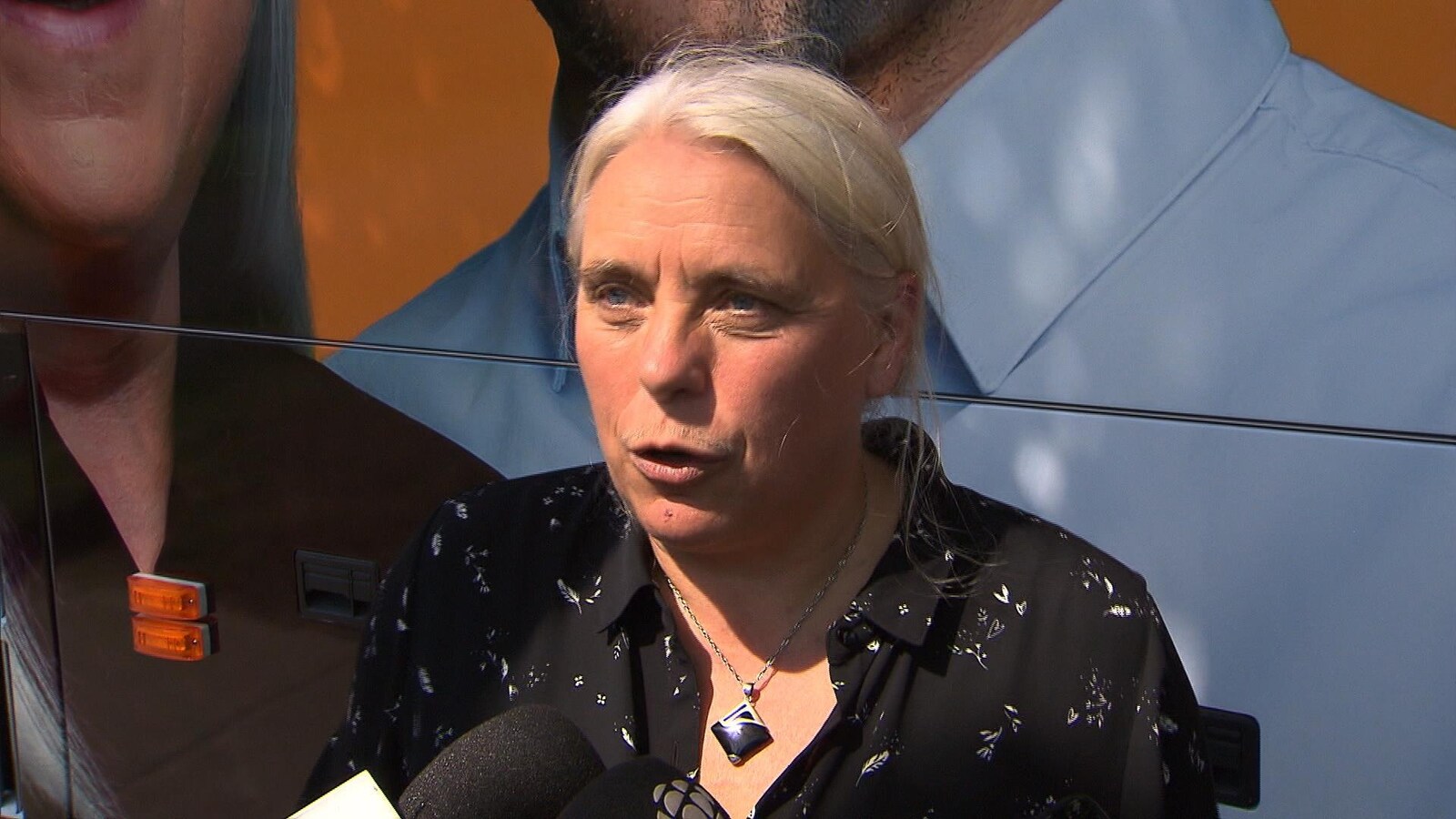 Manon Massé, interrogée par un journaliste devant l'autobus de campagne du parti.