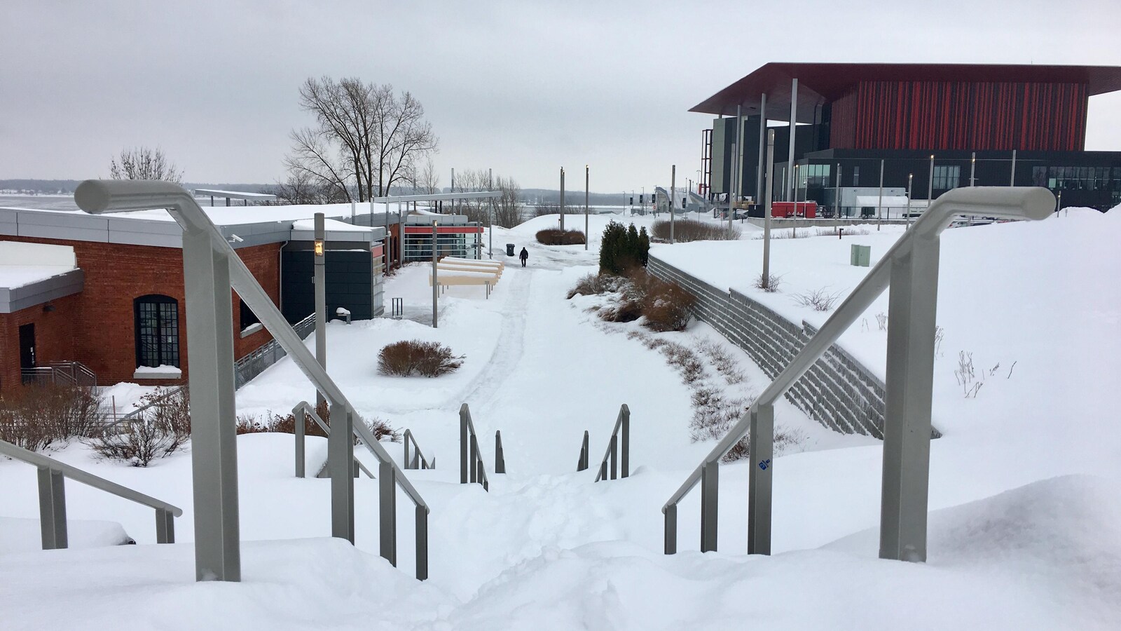 Neige sur des marches près de Boréalis, avec l'amphithéâtre Cogeco au loin.