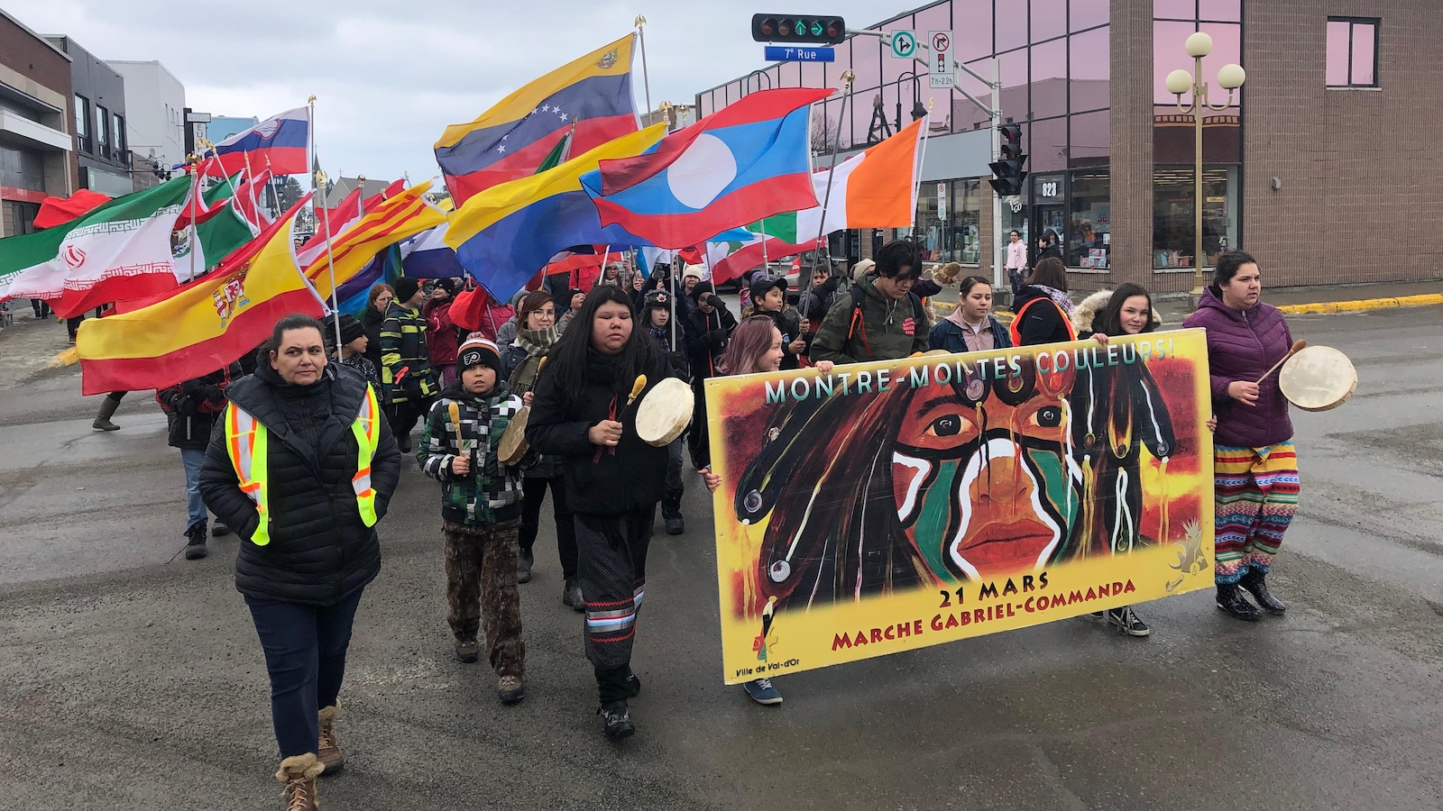Une marche réunissant plusieurs personnes portant des drapeaux au centre-ville de Val-d'Or.