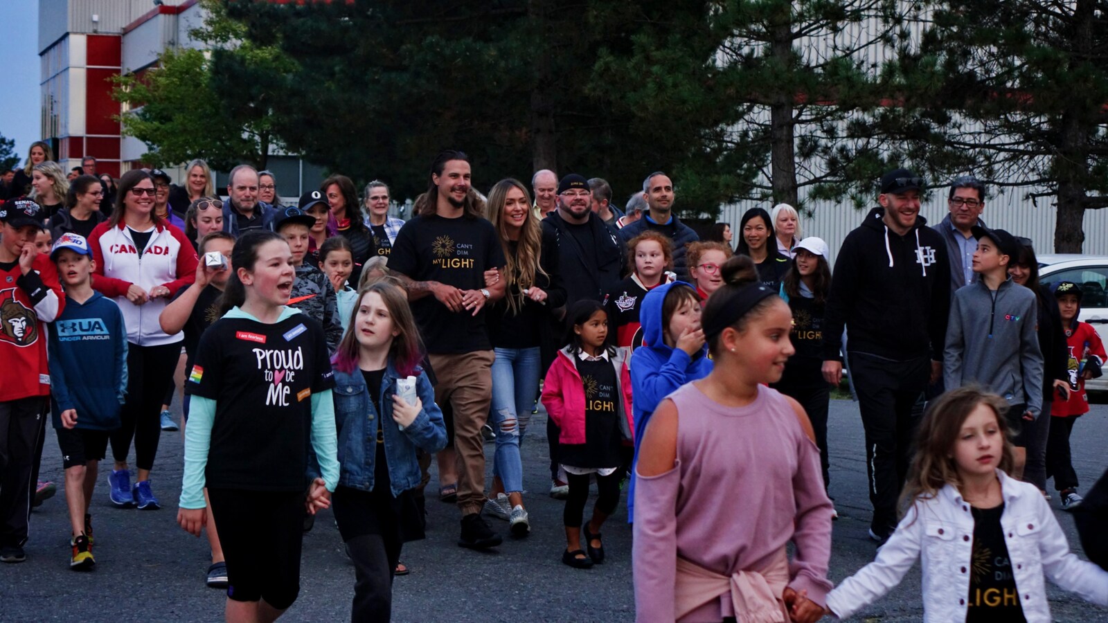Erik Karlsson et sa femme Melinda marchent, entourés de parents et d'enfants.