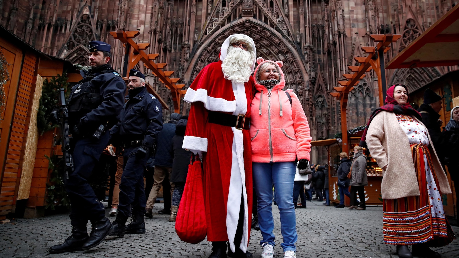 Une femme pose avec le père Noël en présence de policiers.